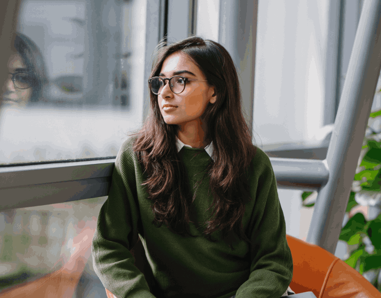 hopeful young woman looking out a window